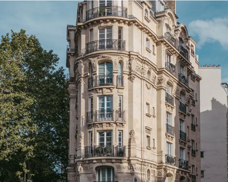un bâtiment avec des balcons et des arbres à l'avant