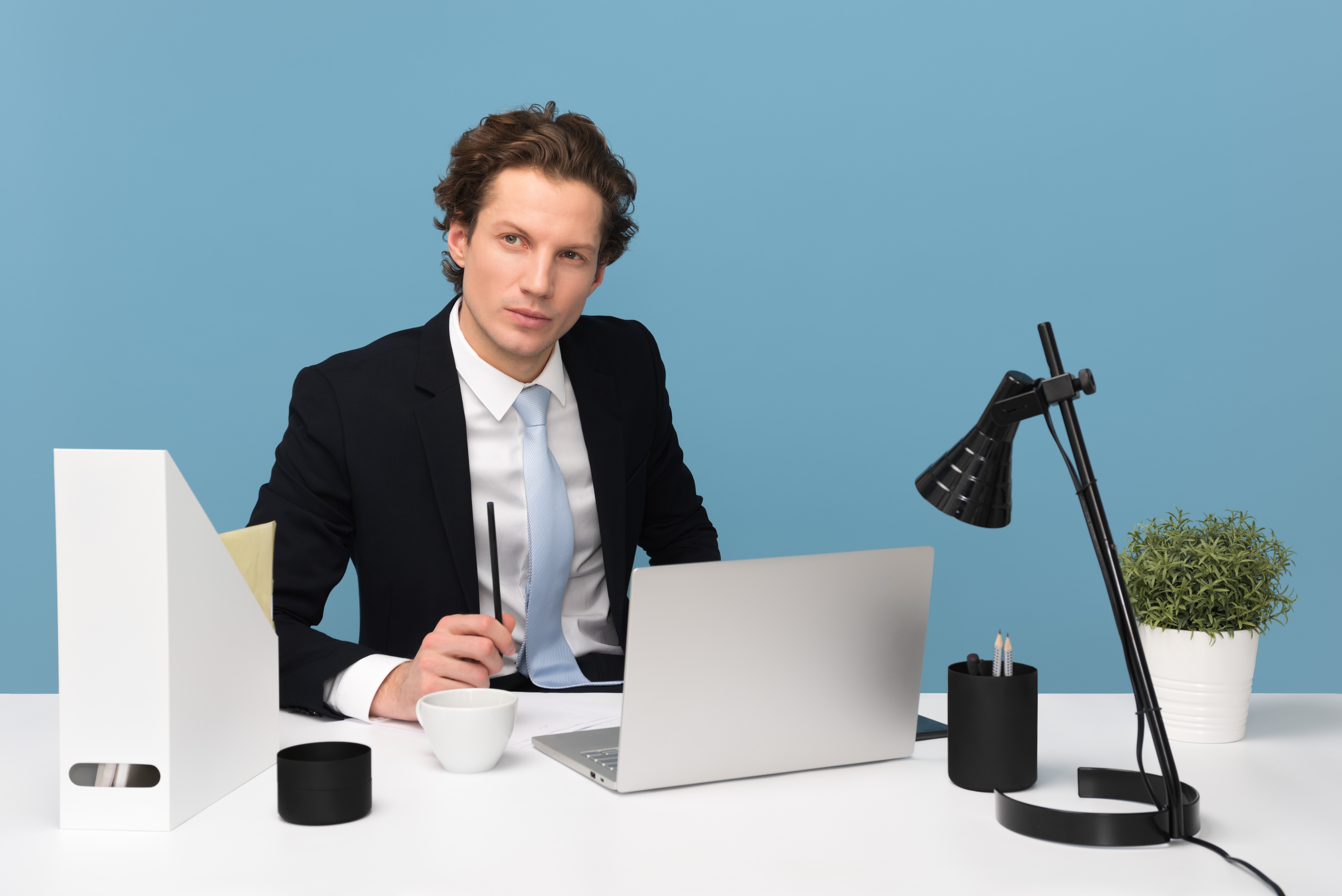 Homme en costume travaillant à un bureau blanc
