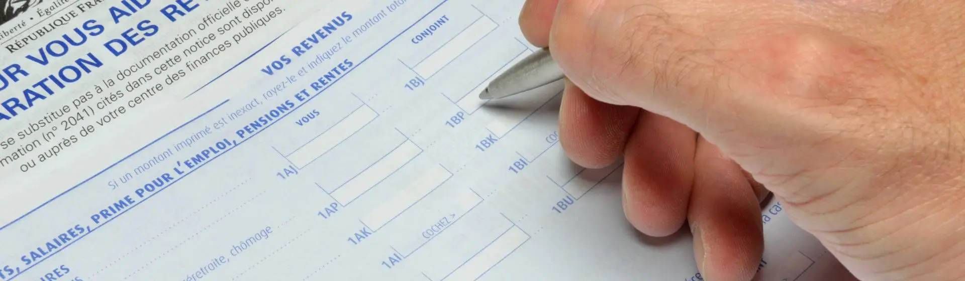 Homme déclarant ses impôts sur une feuille d'imposition