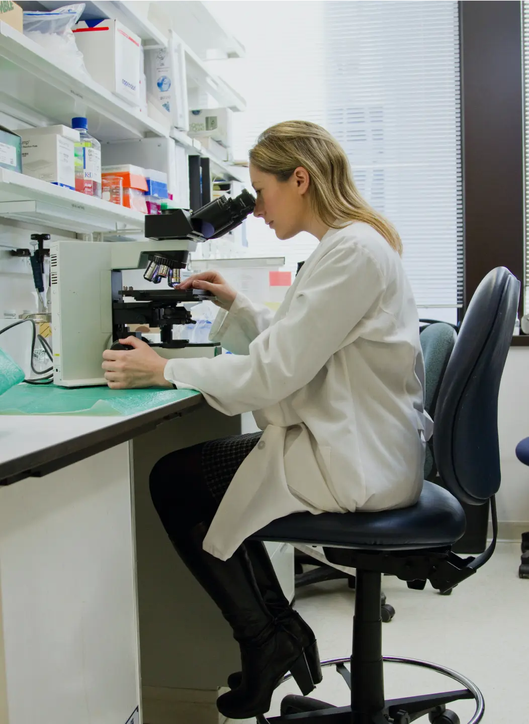 Une scientifique observant au microscope