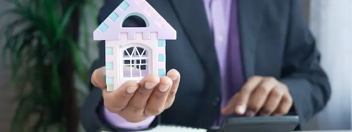 Maison stylisée tenue par un expert