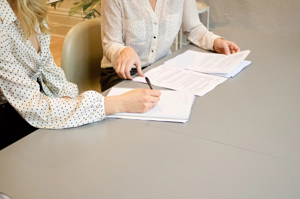 Deux femmes entrain de signer des papiers